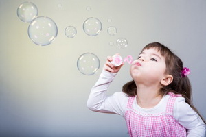 a little girl blowing soap bubbles