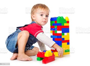 Funny boy is playing with plastic block. isolated on a white background